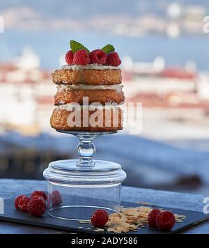 Le fromage à la crème rempli de crêpes garnies de framboises et amandes effilées sur un fond de mer vague côte. Banque D'Images