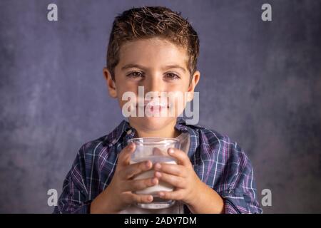 Petit enfant profiter avec un verre de lait Banque D'Images