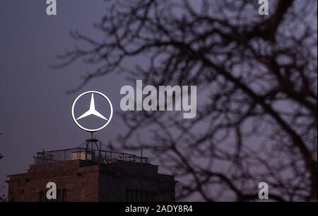 03 décembre 2019, Bade-Wurtemberg, Stuttgart : l'étoile Mercedes sur la station tower brille derrière les branches. Photo : Sebastian Gollnow/dpa Banque D'Images