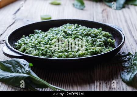 Plat végétalien, épinards risotto à la poêle en fonte, nourriture vegan à base de plantes Banque D'Images