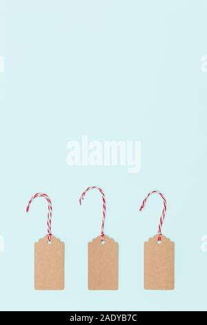 Tags Noël dans un carton avec string rouge et blanc string sur fond bleu clair. Joyeux Noël. Concept des fêtes Banque D'Images