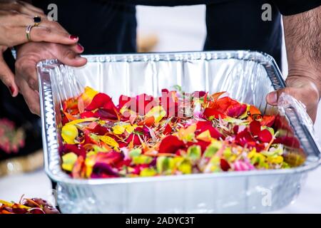 Cérémonie traditionnelle sikh indien articles rituel, donation box, les mains fleurs close up Banque D'Images