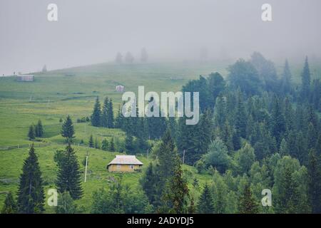 Paysage de montagne dans le brouillard. maison de montagne. Le vieux spooky maison sur la terre de nulle part. Maison en bois au milieu de la terre stérile. Sce Banque D'Images