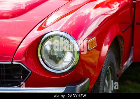 Classique de style ancien vieux rouge vif American car la moitié avant, côté droit, Close up sur verre feux de croisement et feux de signalisation lampes Banque D'Images