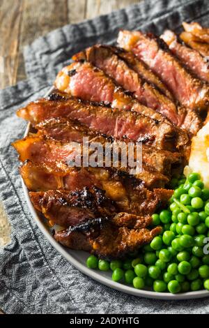 Sucre grillé maison Steak avec pommes de terre et les pois Banque D'Images