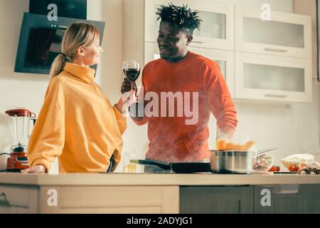 Young couple having date romantique avec du vin rouge dans la cuisine Banque D'Images