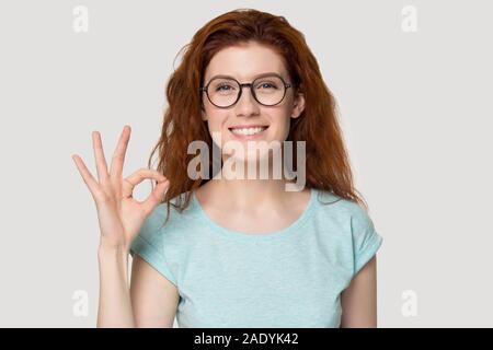 Head shot portrait young smiling woman showing okey geste. Banque D'Images