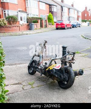 Scooter de moteur brûlé en attente d'être récupéré pour la mise au rebut après avoir été vandalisé et incendié Banque D'Images