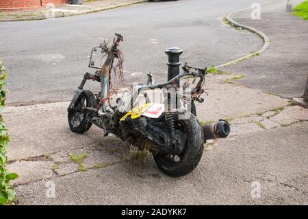 Burnt Out motor scooter attendent d'être chargés sur camion de récupération. Banque D'Images