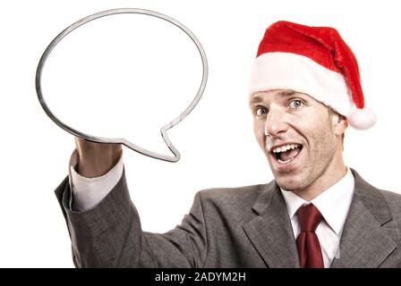 Cheerful businessman wearing a maison de vacances Santa hat holding a blank speech bubble with copy space sur fond blanc Banque D'Images