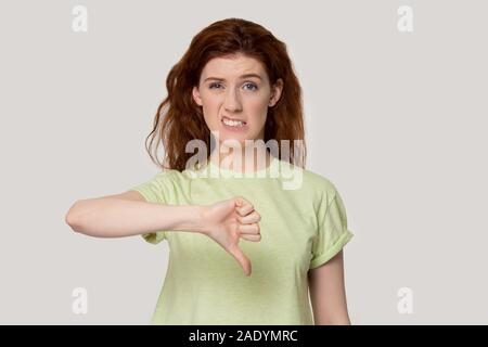 Les jeunes mécontents red-haired woman showing Thumbs down geste. Banque D'Images