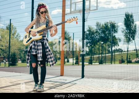 Toute la longueur du musicien concentré à jouer de la guitare à l'extérieur Banque D'Images