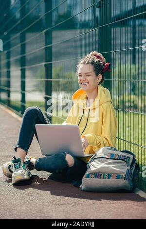 Jeune femme expressive en fermant les yeux et rire seul Banque D'Images