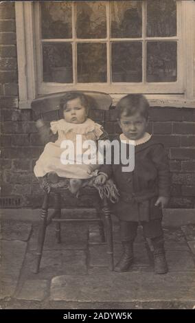 Carte postale photographique du début du XXe siècle montrant deux jeunes enfants. Banque D'Images