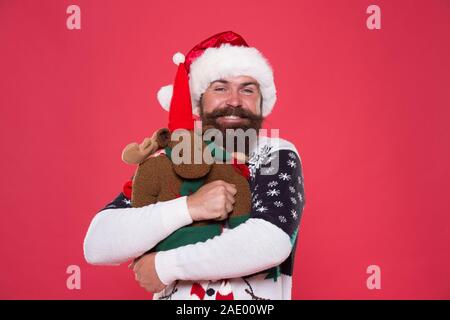 Hug est humeur enhancer. Santa heureux embrasser toy reindeer. Homme barbu dans humeur cool. Super ambiance de vacances. Ambiance de Noël. Envie de faire la fête. Heureux les émotions. Nouvel an. Banque D'Images