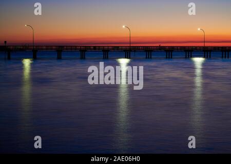 Coucher de soleil sur la jetée dans la baie de Mobile de Owego avec reflets dans l'eau, dans Fairhope Alabama, Etats-Unis. Banque D'Images