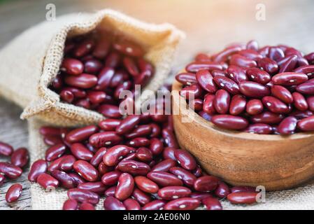 Haricot rouge à bol en bois sur sac contexte / Grains de haricots rouges Banque D'Images