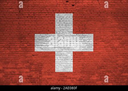 Drapeau suisse représenté dans des couleurs de peinture sur mur en briques anciennes close up. Bannière texturé sur grand mur arrière-plan de maçonnerie Banque D'Images