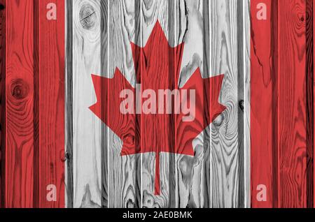 Drapeau du Canada décrit dans des couleurs de peinture sur mur en bois vieux de près. Bannière sur fond rugueux texturé Banque D'Images
