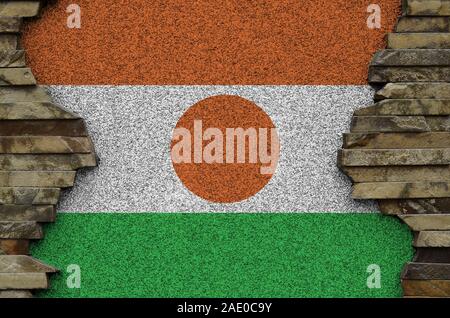 Drapeau du Niger représenté dans des couleurs de peinture sur vieux mur de pierre close up. Bannière texturé sur rock wall background Banque D'Images