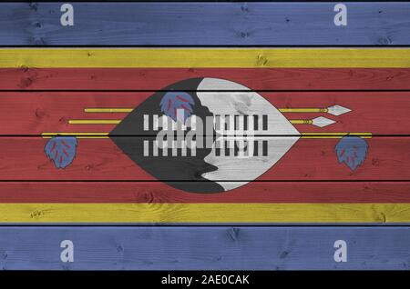 Drapeau Swaziland représenté dans des couleurs de peinture sur mur en bois vieux de près. Bannière sur fond rugueux texturé Banque D'Images