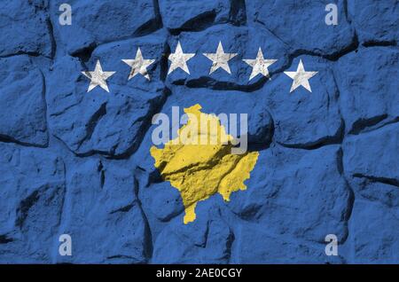 Drapeau du Kosovo représentés dans des couleurs de peinture sur vieux mur de pierre close up. Bannière texturé sur rock wall background Banque D'Images
