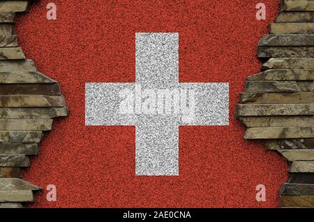 Drapeau suisse représenté dans des couleurs de peinture sur vieux mur de pierre close up. Bannière texturé sur rock wall background Banque D'Images