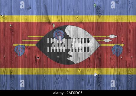 Drapeau Swaziland représenté dans des couleurs de peinture sur mur en bois vieux de près. Bannière sur fond rugueux texturé Banque D'Images