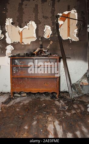 Commode en bois de chambre à coucher brûlée à l'intérieur d'une maison ravagée par un feu Banque D'Images