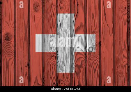 Drapeau suisse représenté dans des couleurs de peinture sur mur en bois vieux de près. Bannière sur fond rugueux texturé Banque D'Images