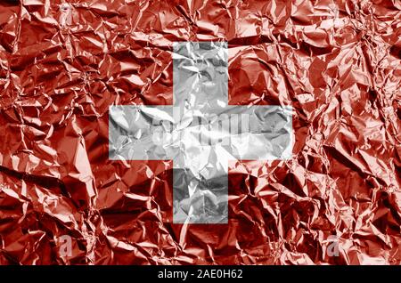 Drapeau suisse représenté dans des couleurs de peinture sur aluminium froissé brillant close up. Bannière sur fond rugueux texturé Banque D'Images