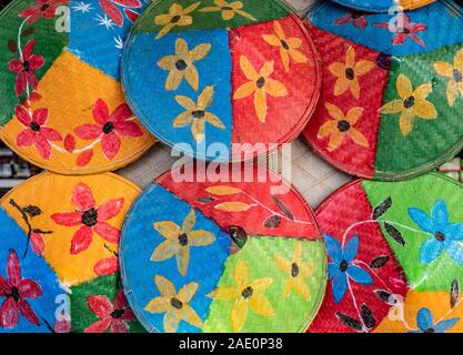 L'agriculteur coniques peintes de couleurs vives avec des motifs de fleurs et chapeaux couleurs primaires lumineuses ornent une boutique le long de la rivière Chindwin au Myanmar (Birmanie) Banque D'Images