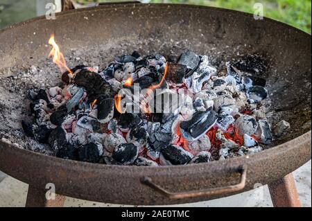 Barbecue fosse avec rougeoyant et Flaming Hot briquettes de charbon Le charbon ou la texture de fond alimentaire Plan Vue de dessus Banque D'Images