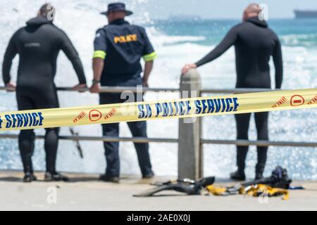 Service de police d'Afrique du Sud les membres de l'équipe de l'unité de plongée de la côte derrière le crime de bande jaune enquête à la côte sur une recherche et sauvetage Banque D'Images