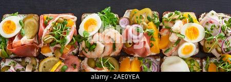 Vue panoramique tourné de smorrebrod traditionnels sandwiches avec œufs durs sur la surface gris Banque D'Images