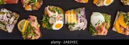 Vue panoramique tourné de pain de seigle avec de savoureux sandwiches smorrebrod sur surface grise Banque D'Images