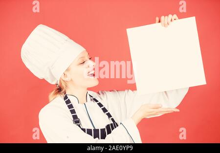 Woman in hat cook et tablier. menu du restaurant. Suivre un régime culinaire. happy woman la cuisson des aliments sains par recette. chef professionnel en cuisine. Cuisine. Femme au foyer avec livre de cuisine. se sent la faim. Banque D'Images