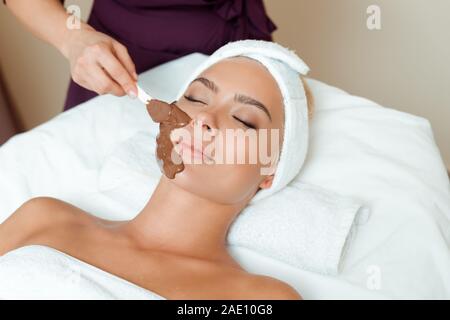 Portrait de l'application de masque de visage sur cosmetologist attractive woman in spa Banque D'Images