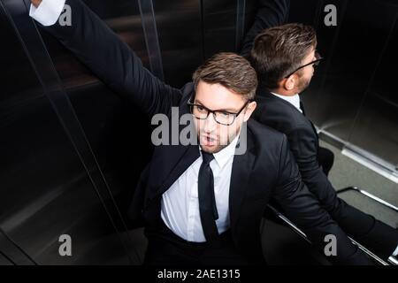 Portrait de l'homme effrayé en costume avec la claustrophobie dans l'élévateur Banque D'Images