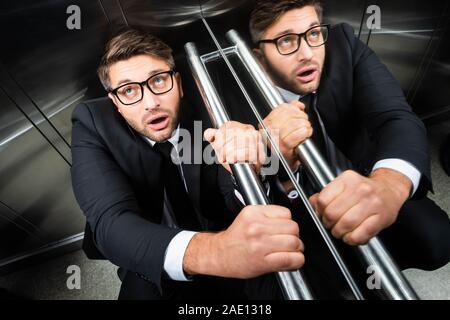 High angle view of woman in suit avec peur de claustrophobie dans l'élévateur Banque D'Images