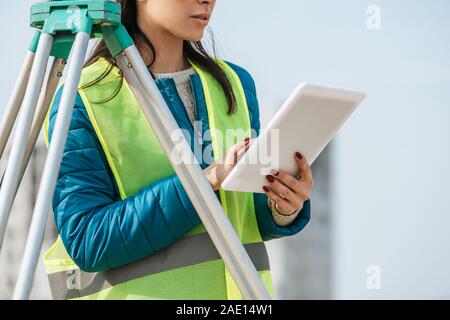 Portrait de surveyor using digital tablet à côté de niveau de mesure Banque D'Images