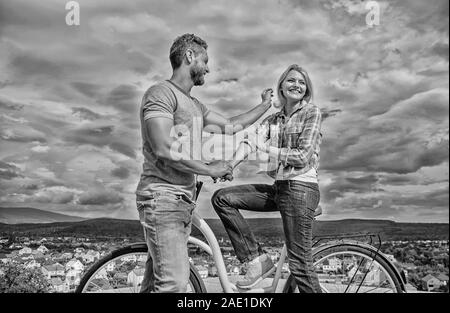 Comment satisfaire les filles alors qu'à vélo. Homme avec barbe et dame blonde timide sur la première date. Couple tout juste de faire connaissance. Femme se sent timide en société avec macho attrayant. Ramasser des fille. Banque D'Images