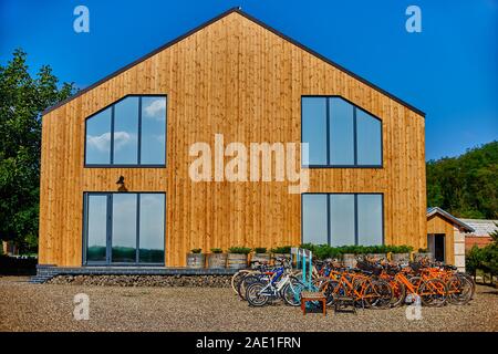 Façade en bois de la maison en bois. En bois jaune bordés. Fenêtres panoramiques. Vue parfait reflet dans une fenêtre de ciel bleu. Le concept d'éco-architecture Banque D'Images