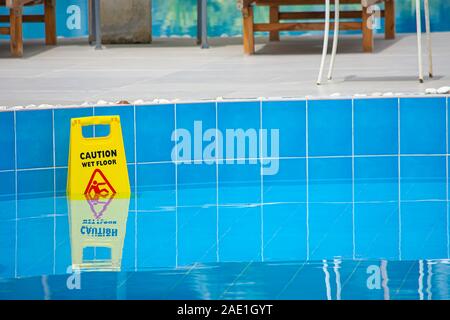 Plaque de sol humide au bord de la piscine en plastique jaune. Banque D'Images