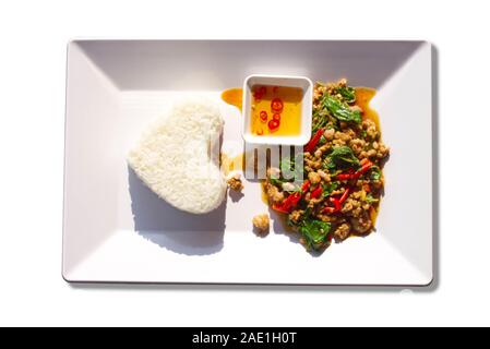 Sauté de porc riz avec des feuilles de basilic sur un fond blanc. Banque D'Images
