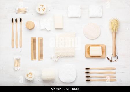 Zéro déchets avec accessoires naturel biodégradable. Brosses à dents en bambou à la main, savon sans emballage pains shampooings, coton-tiges pads, produits d'hygiène luffa sur blanc, vue du dessus, selective focus Banque D'Images