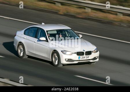 2014 BMW 316I se trouble ; auto voiture en déplacements à grande vitesse sur l'autoroute M61 ; ralentir la vitesse d'obturation de l'appareil photo avec le mouvement du véhicule Banque D'Images