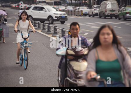 Chengdu, Chine - Juillet 2019 : les navetteurs à cheval sur les bicyclettes, scooters et motocyclettes sur la rue animée en été, dans la province du Sichuan Banque D'Images