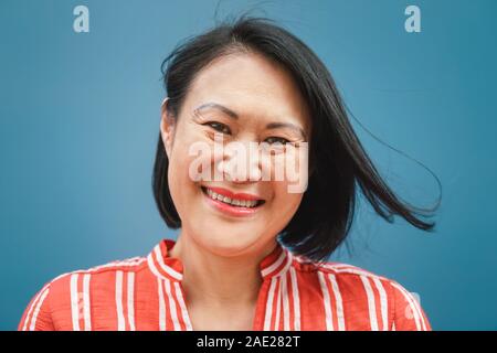 Happy Asian woman portrait contre fond bleu - femme chinoise s'amusant posing in front of camera Banque D'Images