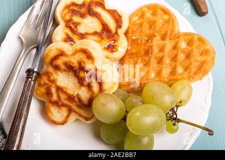 Petit-déjeuner sain composé de gaufres, crêpes fleurs coeurs Banque D'Images